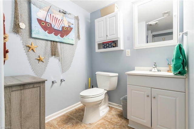 bathroom with baseboards, tile patterned floors, toilet, and vanity
