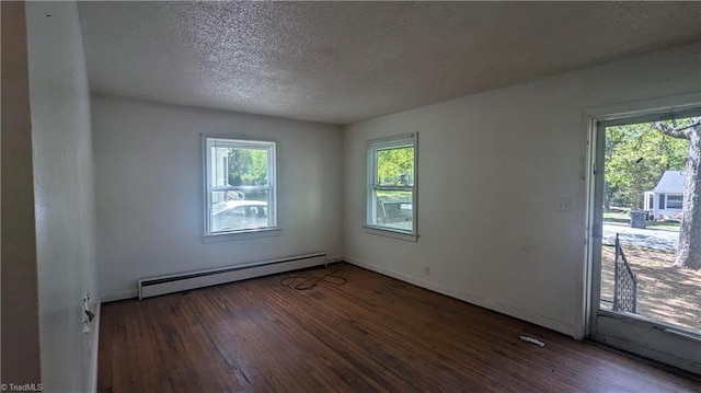 2806 Robin Hood Dr, Greensboro, NC 27408 - empty room with a baseboard heating unit, hardwood / wood-style flooring, a healthy amount of sunlight, and a textured ceiling