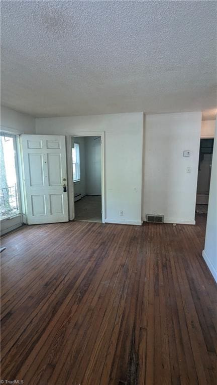 2806 Robin Hood Dr, Greensboro, NC 27408 - unfurnished living room with visible vents, dark wood-style floors, a textured ceiling, and a healthy amount of sunlight