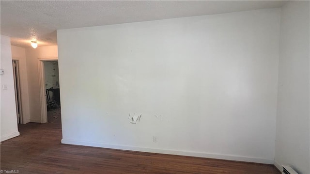 2806 Robin Hood Dr, Greensboro, NC 27408 - unfurnished room featuring baseboard heating, baseboards, wood finished floors, and a textured ceiling