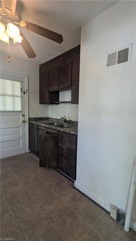 2806 Robin Hood Dr, Greensboro, NC 27408 - kitchen with dark countertops, visible vents, a ceiling fan, a sink, and dark brown cabinetry
