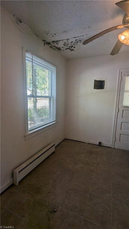2806 Robin Hood Dr, Greensboro, NC 27408 - tiled spare room with ceiling fan, a textured ceiling, and a baseboard radiator