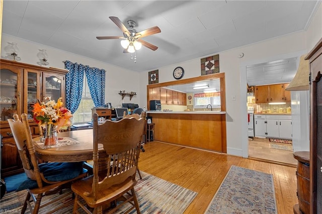 dining space with light wood-type flooring, ceiling fan, and sink