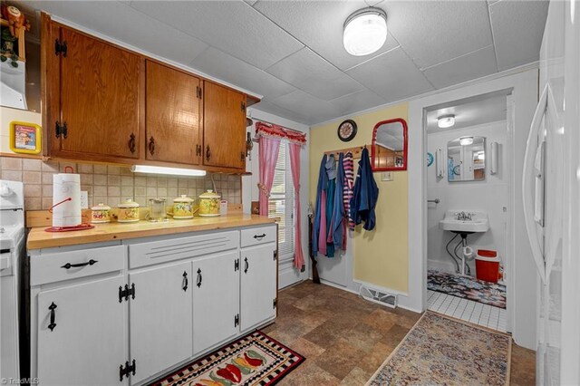 kitchen with backsplash and white cabinetry