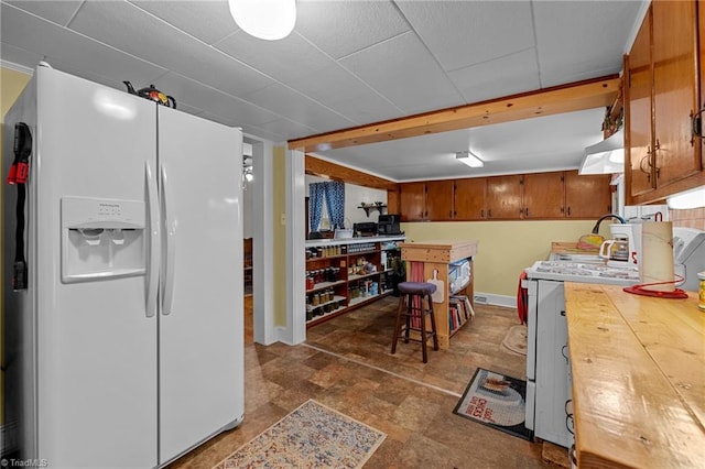 kitchen featuring a kitchen breakfast bar and white fridge with ice dispenser