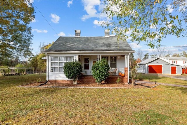 bungalow-style home with an outbuilding, a front lawn, and covered porch