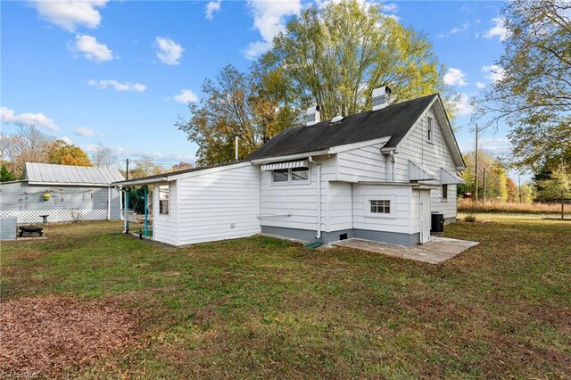 view of side of home featuring a yard and central AC