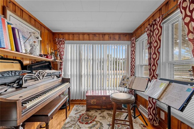 sitting room with wood walls and light hardwood / wood-style flooring