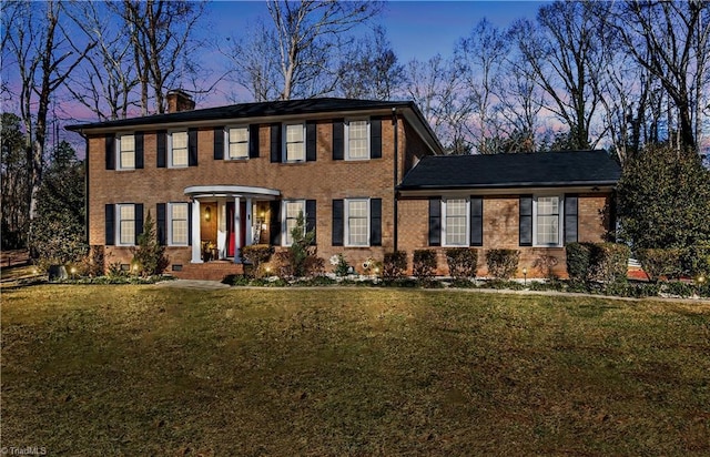 colonial-style house featuring a yard