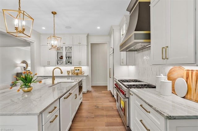 905 Brookside Dr, Greensboro, NC 27408 - kitchen featuring a sink, an inviting chandelier, white cabinetry, custom range hood, and stainless steel stove