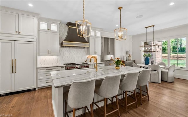 905 Brookside Dr, Greensboro, NC 27408 - kitchen with recessed lighting, paneled refrigerator, wood finished floors, a sink, and premium range hood
