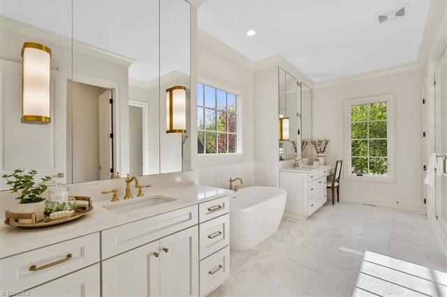 905 Brookside Dr, Greensboro, NC 27408 - full bathroom with two vanities, a sink, a freestanding bath, marble finish floor, and ornamental molding