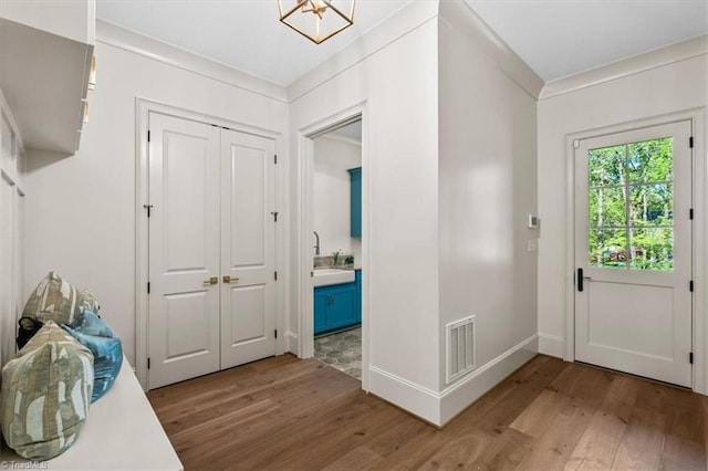 905 Brookside Dr, Greensboro, NC 27408 - foyer entrance with light wood-style flooring, visible vents, crown molding, and baseboards