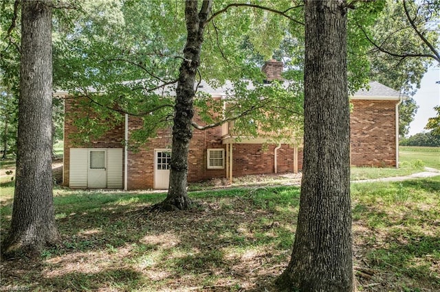 view of front of property featuring a front yard and a storage unit