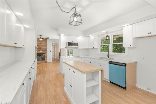 kitchen with white cabinets, appliances with stainless steel finishes, and hanging light fixtures