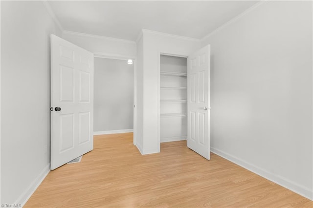 unfurnished bedroom featuring ornamental molding, a closet, and light hardwood / wood-style floors