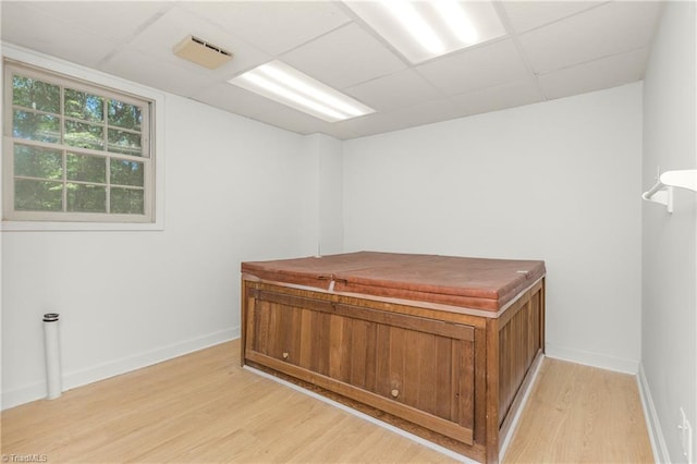 office space with a drop ceiling and light hardwood / wood-style flooring