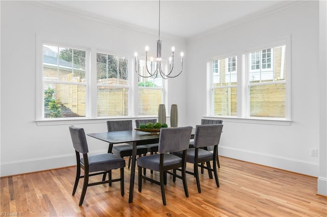 dining area featuring crown molding, a chandelier, and light wood-type flooring