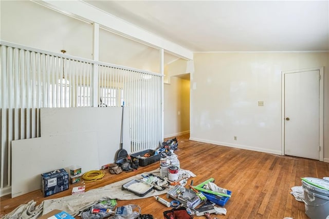 empty room featuring lofted ceiling with beams and wood finished floors