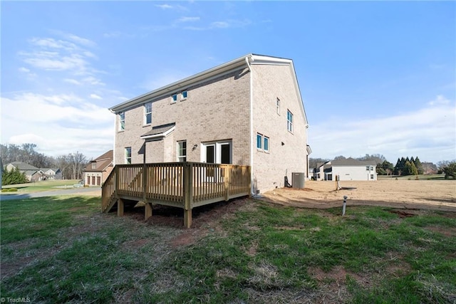 rear view of property with a wooden deck, cooling unit, and a lawn