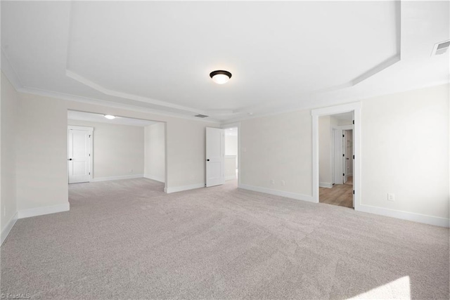 spare room with baseboards, light colored carpet, and a raised ceiling