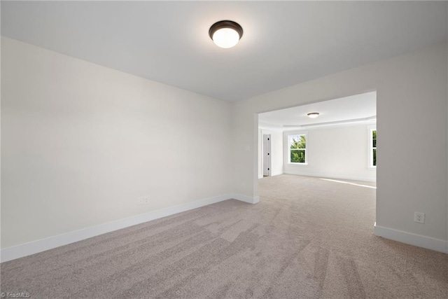spare room featuring baseboards and carpet