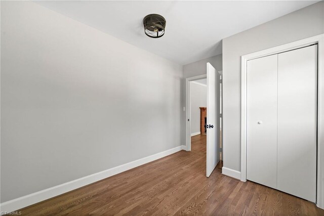 unfurnished bedroom with a closet and hardwood / wood-style flooring