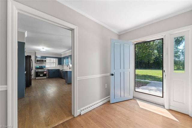 doorway to outside featuring a baseboard heating unit, ornamental molding, light hardwood / wood-style flooring, and sink