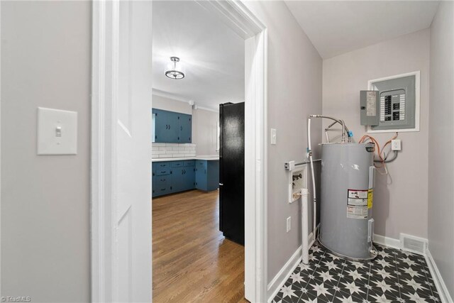 utility room with electric panel and water heater