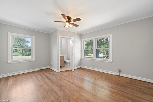 unfurnished bedroom with ensuite bath, a baseboard radiator, wood-type flooring, and ceiling fan