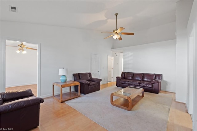 living room featuring light hardwood / wood-style flooring, ceiling fan, and vaulted ceiling