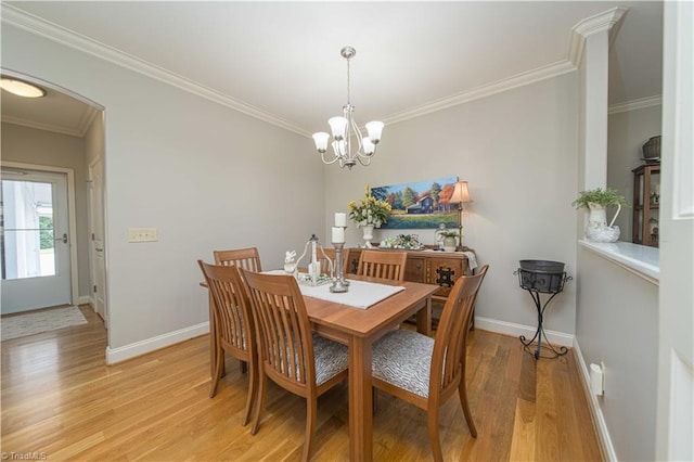 dining room with ornamental molding, baseboards, a notable chandelier, and light wood finished floors