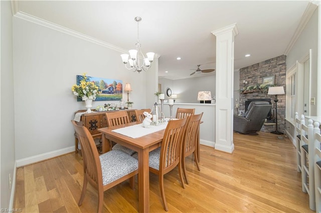 dining space featuring light wood finished floors, crown molding, ornate columns, and ceiling fan with notable chandelier
