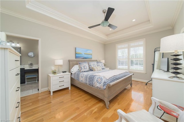 bedroom featuring light wood finished floors, a raised ceiling, baseboards, ceiling fan, and ornamental molding