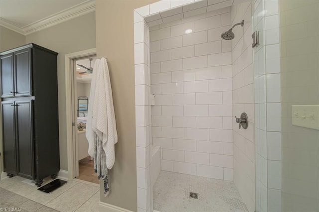full bath featuring tiled shower, baseboards, tile patterned floors, and crown molding