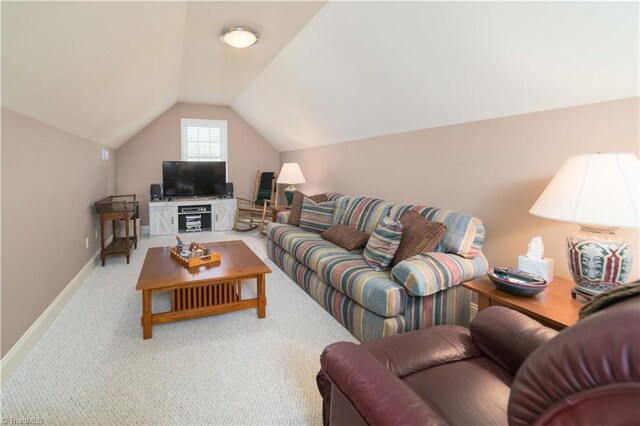 carpeted living area featuring lofted ceiling and baseboards