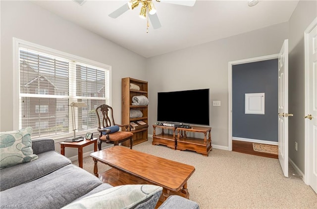 carpeted living area with baseboards and ceiling fan