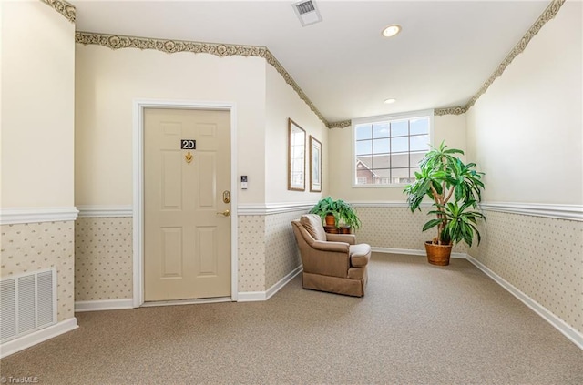 interior space with wainscoting, carpet flooring, wallpapered walls, and visible vents