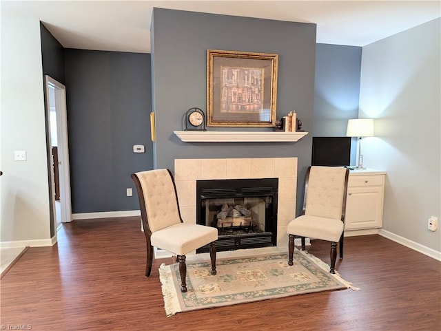 living area with baseboards, dark wood-style floors, and a fireplace