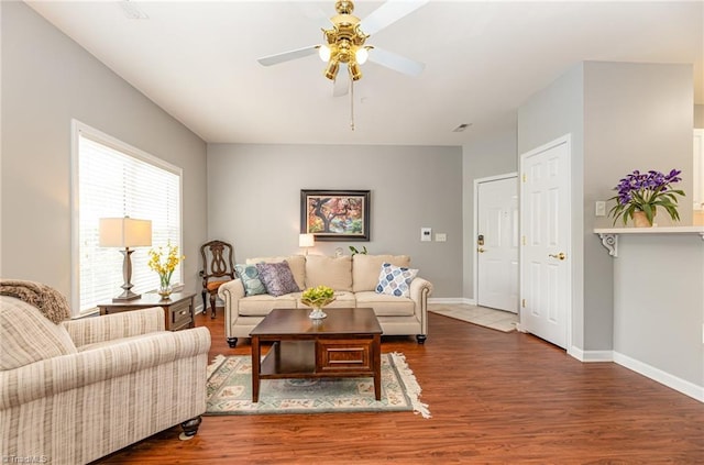 living room with baseboards, ceiling fan, and wood finished floors