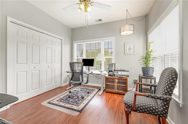 office area featuring visible vents, a ceiling fan, baseboards, and wood finished floors