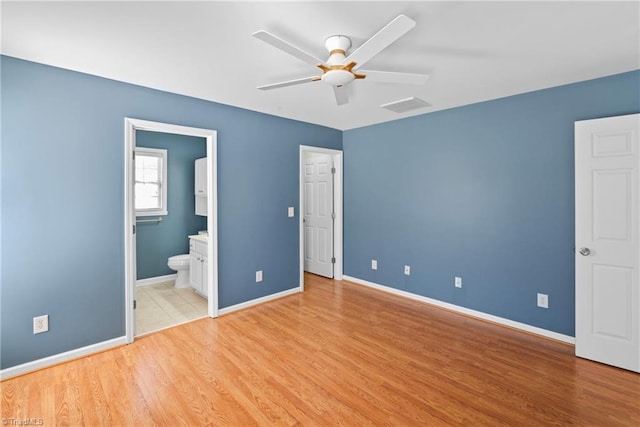 unfurnished bedroom with visible vents, baseboards, light wood-style floors, and ensuite bath