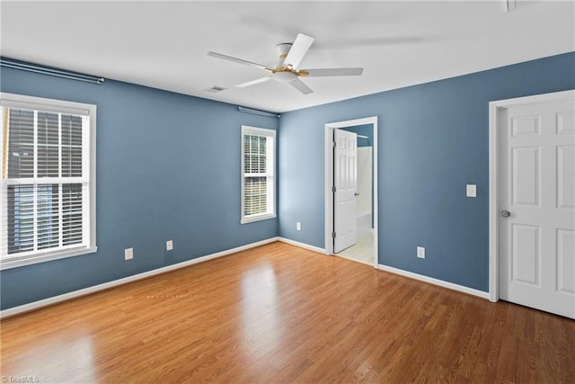 unfurnished bedroom featuring visible vents, baseboards, wood finished floors, and a ceiling fan