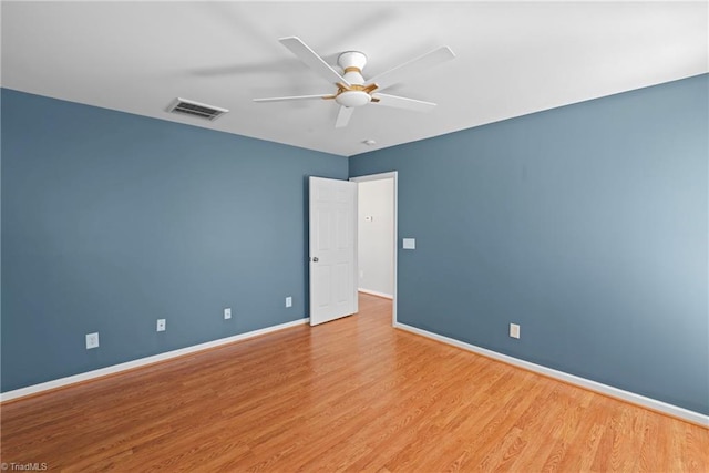 unfurnished room featuring ceiling fan, visible vents, baseboards, and wood finished floors