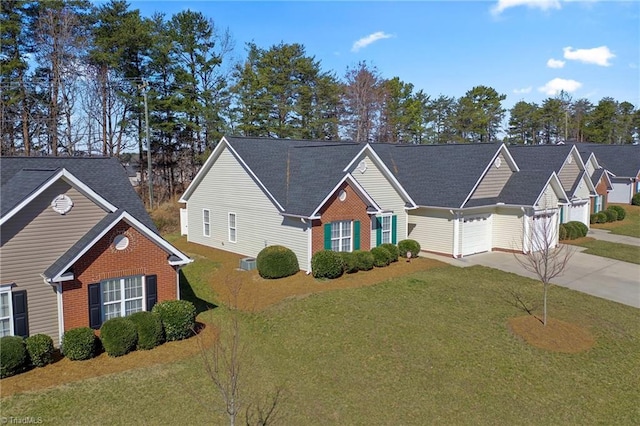 view of front of home featuring a front yard, brick siding, and driveway