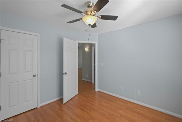 unfurnished bedroom featuring ceiling fan, baseboards, and wood finished floors