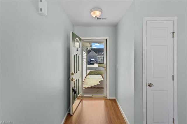 doorway featuring visible vents, baseboards, and wood finished floors