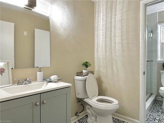 bathroom with toilet, a shower with shower door, vanity, and tile patterned flooring