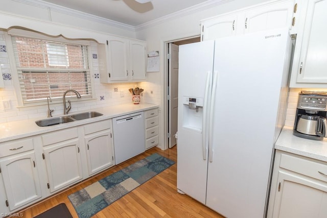 kitchen featuring backsplash, white appliances, sink, light hardwood / wood-style flooring, and white cabinets