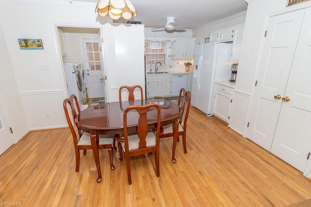 dining area with ceiling fan, light wood-type flooring, separate washer and dryer, and sink